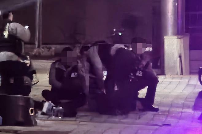 The man who shot a police inspector, center, gets apprehended by police in Gwangju early Wednesday. [YONHAP]