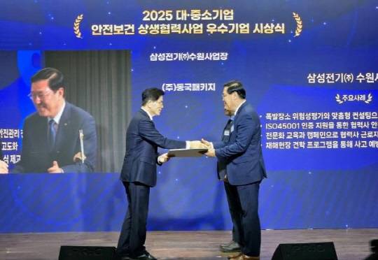 임승용(오른쪽) 삼성전기 글로벌안전센터장이 26일 열린 대·중소기업 안전보건 상생협력사업 참여기업 협약식에서 김문수(왼쪽) 고용노동부 장관으로부터 우수기업 선정서를 받고 있다. <삼성전기 제공>