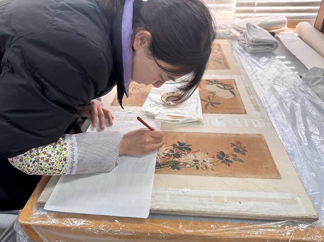 지난 21일 베이징 고궁박물원의 서화복원실에서 문화재 전문가가 옛 그림 작품을 복원하고 있다. 신경진 기자