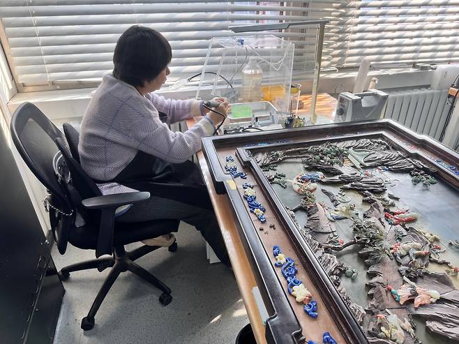 지난 21일 베이징 고궁박물원의 상감복원실에서 한 문화재 전문가가 황실의 부조 작품을 전용 도구를 사용해 복원하고 있다. 신경진 기자