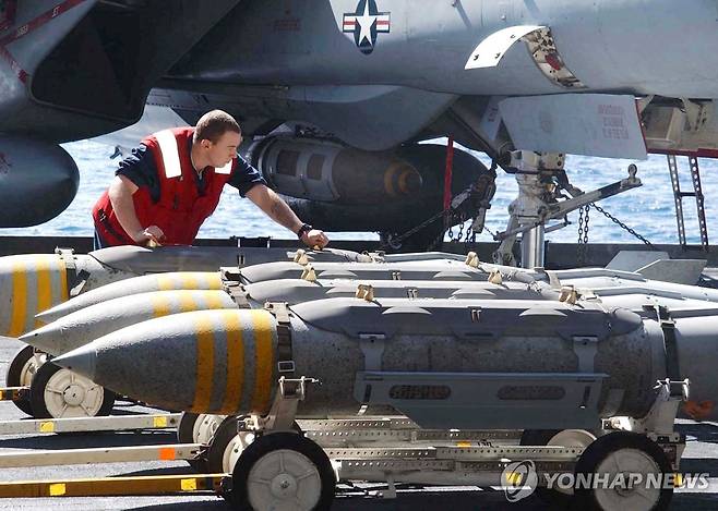 2002년 미 항공모함 존 F. 케네디호 갑판의 F-14 톰캣 전투기 옆에서 2천 파운드급 항공폭탄인 MK-84를 옮기는 미군 병사들 [로이터 연합뉴스 자료사진. 재판매 및 DB 금지]
