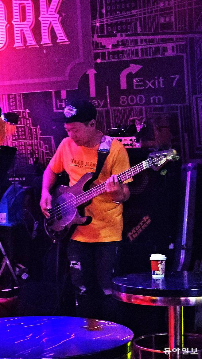 가오리에서 영감을 받은 디자인으로 만들어진 ‘뮤직맨 스팅레이’ 4현 베이스를 연주하는 사람.