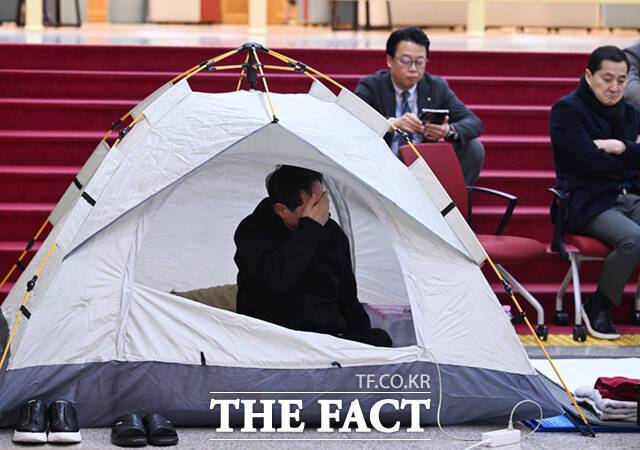 마은혁 헌법재판관 추가 임명에 반대하며 단식농성에 돌입한 박수영 국민의힘 의원이 4일 서울 여의도 국회 로텐더홀에 마련된 텐트에서 얼굴을 감싸쥐고 있다.