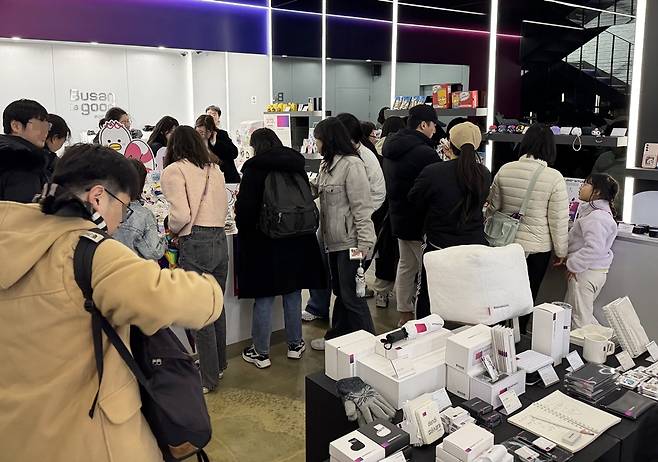 부산도시브랜드숍 내부가 방문객들로 북적이고 있다. 매장에는 부산 특화 상품들이 진열돼 있고, 시민들과 관광객들이 쇼핑을 즐기고 있다.