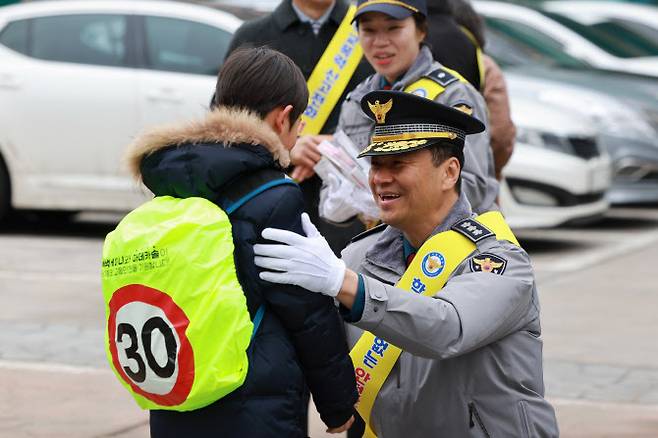 박현수 서울경찰청장 직무대리가 5일 서울 서대문구 고은초등학교에서 신학기를 맞아 등교하는 초등학생에게 가방 형광덮개를 씌워주고 있다. (사진=연합뉴스)