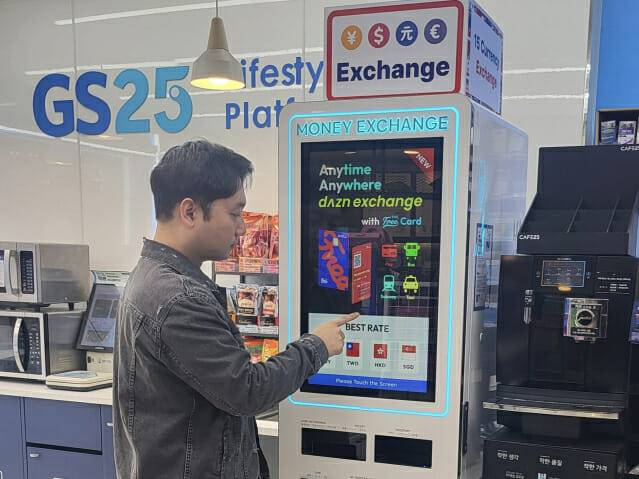 GS25에서 고객이 환전 키오스크로 외화 환전 서비스를 이용하고 있다