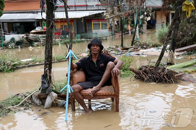 4일(현지시간) 인도네시아 자카르타 외곽 베카시에서 폭우가 내린 후 홍수가 주택가를 덮치자 한 남성이 망연자실한 표정으로 의자에 앉아 있다. 2025.3.6 ⓒ 로이터=뉴스1