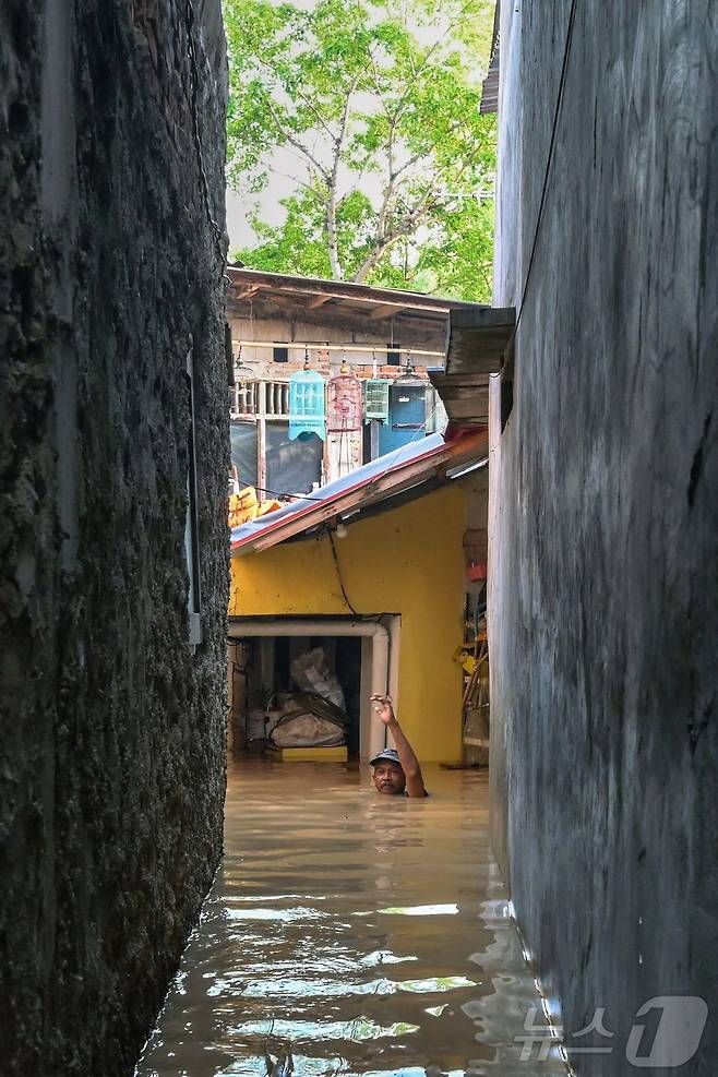 3일(현지시간) 자카르타 페하텐 바라트 지역에서 밤사이 폭우가 내린 후 한 남성이 목 깊이의 홍수 속을 걸어가고 있다. 2025.3.6 ⓒ AFP=뉴스1