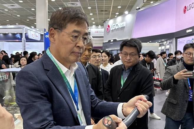 신학철 LG화학 부회장이 6일 서울 강남구 코엑스에서 열린 '인터배터리 2025'에서 LG화학 부스를 찾아 초고중합도 PVC로 만든 전기차 충전용 케이블을 보고 있다. LG화학 제공