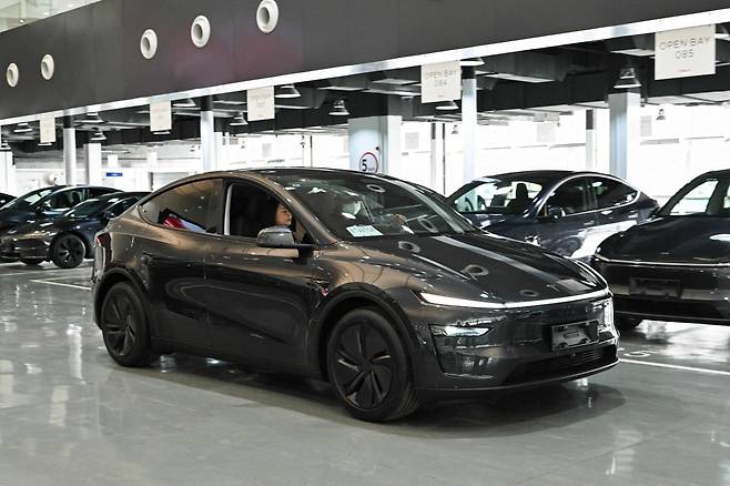 지난달 중국 베이징의 테슬라 배송 센터에서 새 모델Y를 구입한 고객이 차량을 살펴보고 있다. /AFP