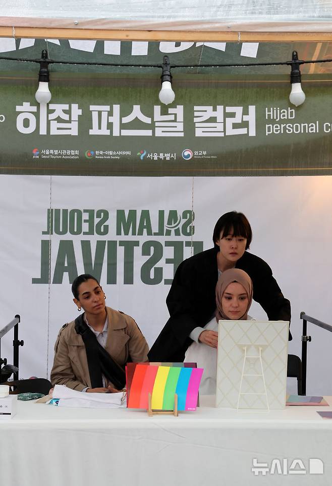 [서울=뉴시스] 배훈식 기자 = 살람서울 페스티벌이 열린 22일 오후 서울 종로구 광화문광장에 마련된 중동 국가 문화 체험 부스에서 시민들이 히잡과 헤나 등을 체험하고 있다. 2024.10.22. dahora83@newsis.com