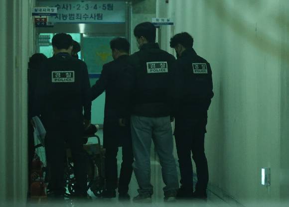 대전서부경찰서에서 첫 대면조사를 마친 대전 초등생 살해 교사 명모(40대) 씨가 조사실을 나오고 있다. 경찰들이 명씨를 유치장에 입감하기 위해 이동시키고 있다. 2025.3.7 [사진=연합뉴스]