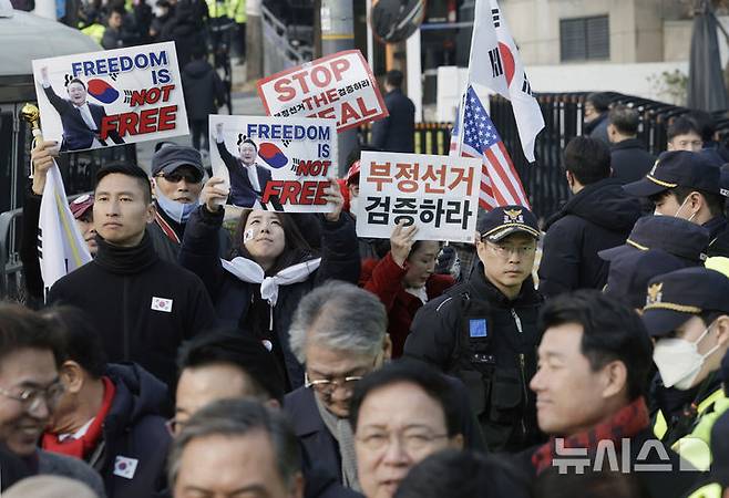 [서울=뉴시스] 최동준 기자 = 법원이 윤석열 대통령의 구속취소 청구를 인용한 7일 서울 용산구 한남동 대통령 관저 앞에서 국민의힘 탄핵반대 당협위원장 모임 관계자들이 윤 대통령 석방을 환영 입장문을 발표하는 뒤로 지지자들이 손팻말을 흔들고 있다. 2025.03.07. photocdj@newsis.com