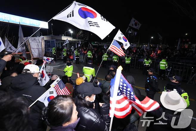 법원이 내란 수괴 혐의로 구속기소된 윤석열 대통령의 구속 취소를 인용한 7일 경기 의왕시 서울구치소 앞에서 윤 대통령 지지자들이 구호를 외치고 있다. 2025.3.7/뉴스1 ⓒ News1 신웅수 기자