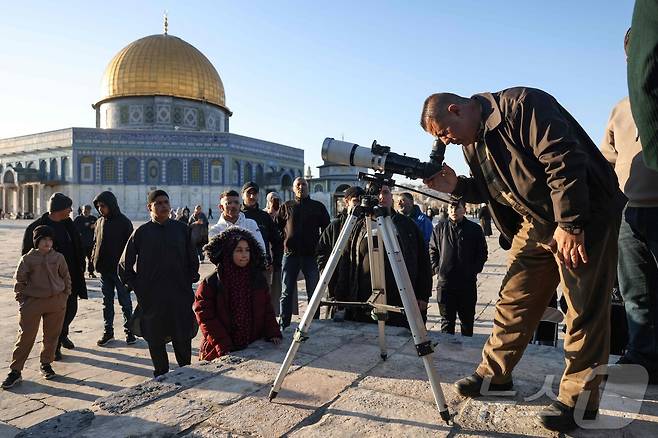 지난달 28일(현지시간) 한 무슬림이 예루살렘 구시가지 알아크사 모스크 단지에서 이슬람 금식월인 라마단의 시작을 알리기 위해 망원경으로 초승달을 관측하고 았다. ⓒ AFP=뉴스1