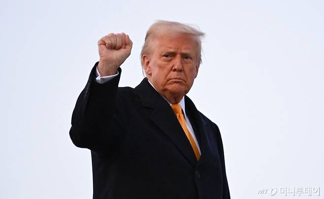 (워싱턴 AFP=뉴스1) 우동명 기자 = 도널드 트럼프 미국 대통령이 7일(현지시간) 플로리다주 마러라고 리조트로 가기 위해 워싱턴 인근 앤드루스 합동 기지서 전용기를 타며 주먹을 불끈 쥐고 있다. 2025.03.08  ⓒ AFP=뉴스1  Copyright (C) 뉴스1. All rights reserved. 무단 전재 및 재배포,  AI학습 이용 금지. /사진=(워싱턴 AFP=뉴스1) 우동명 기자