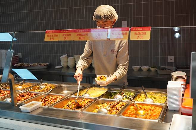 중국 한 저가형 로컬 패스트푸드 점에서 점원이 음식을 담고 있다./사진=현지언론 캡쳐