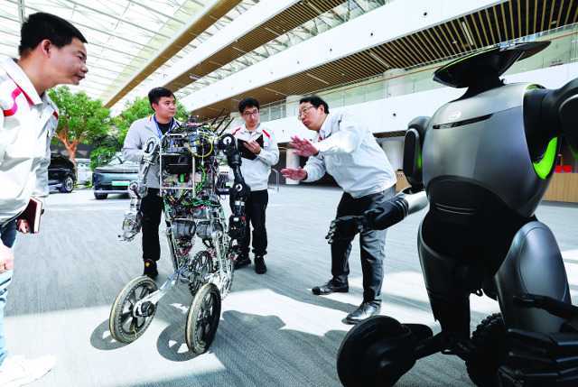 펑 CEO가 인공지능(AI) 로봇에 대해 배우고 있는 모습. 전국인민대표대회 대표 중 한 명이기도 한 그는 올해 전인대에서 정책 지원과 효율적 시장 메커니즘을 통해 신에너지차 산업을 발전시킬 것을 촉구했다. 신화연합뉴스