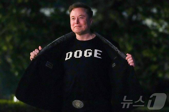 일론 머스크 미국 정부효율부(DOGE) 수장이 9일(현지시간) 도널드 트럼프 대통령과 플로리다에서 주말을 보낸 뒤 워싱턴 백악관에 도착하며 ‘DOGE’가 쓰인 셔츠를 보여 주고 있다. 2025.03.10 ⓒ AFP=뉴스1 ⓒ News1 우동명 기자