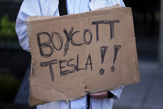 9일(현지시간) 포르투갈 리스본 테슬라 전시장 인근에서 열린 시위에서 '보이콧 테슬라'(Boycott TESLA) 피켓을 들고 있는 시위자. AP=연합뉴스