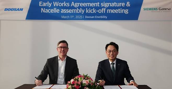 윤요한 두산에너빌리티 파워서비스영업총괄 전무(오른쪽)가 지난 11일 두산에너빌리티 창원 본사에서 열린 지멘스가메사와 사전업무착수협약(EWA) 체결식에서 펠크 머던 지멘스가메사 나셀 생산총괄 박사와 '창원 풍력발전 신규 공장 구축을 위한 사전업무착수협약'을 체결한 뒤 기념촬영을 하고 있다. 두산에너빌리티 제공