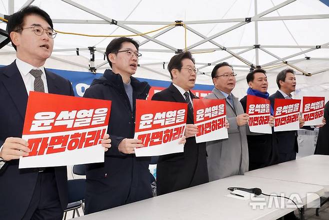 [서울=뉴시스] 황준선 기자 = 이재명 더불어민주당 대표가 12일 서울 종로구 경복궁 앞 천막 농성장에서 열린 국난극복을 위한 시국간담회에서 참석자들과 구호를 외치고 있다. 왼쪽부터 박용진 전 의원, 김경수 전 경남지사, 이 대표, 김부겸 전 국무총리, 이광재 전 국회 사무총장, 임종석 전 대통령 비서실장. (공동취재) 2025.03.12. photo@newsis.com