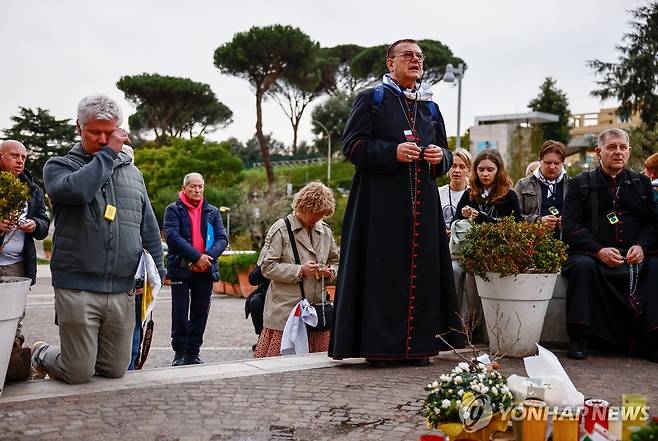11일(현지시간) 교황이 입원한 로마 제멜리 병원에서 교황 쾌유 기원하는 사람들 [로이터 연합뉴스. 재판매 및 DB 금지]