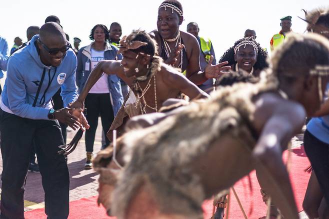 보츠와나 사상 첫 올림픽 금메달을 딴 레칠레 테보고가 13일 가바로네 써 세리즈 국제공항에서 열린 환영행사에서 축하 공연을 펼치는 전통 무용단으로부터 춤 초대를 받고 있다. 테보고는 파리 올림픽 남자 200m에서 보츠와나 역사상 첫 금메달을 따고 1600m 계주에서도 은메달을 목에 걸었다. 모크위치 마시시 대통령은 테보고의 위업을 기리기 위해 이날 오후를 반나절 공휴일로 선포했다. 2024.08.13 /AFPBBNews=뉴스1