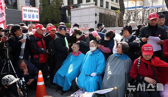 [서울=뉴시스] 김선웅 기자 = 헌재의 윤석열 대통령에 대한 탄핵심판 선고가 임박한 13일 서울 종로구 헌법재판소 앞에서 친 윤 성향 시민들이 탄핵을 반대하며 삭발을 하고 있다. 2025.03.13. mangusta@newsis.com