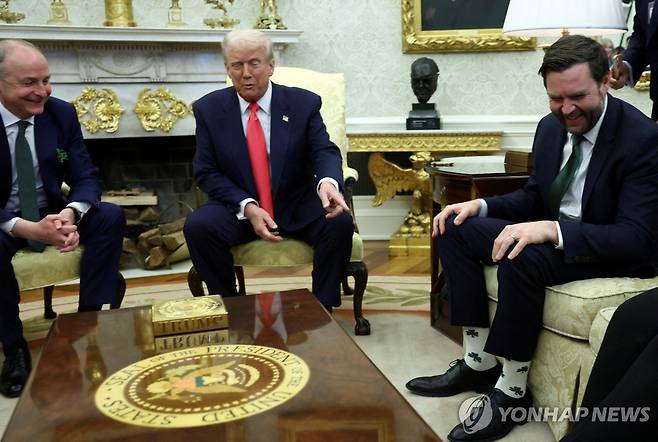 JD밴스 부통령이 신은 토끼풀 무늬 양말을 가리켜보이는 도널드 트럼프 미 대통령 (워싱턴DC 로이터=연합뉴스) 12일(현지시간) 도널드 트럼프 미 대통령이 백악관에서 미할 마틴 아일랜드 총리와 정상회담을 하던 중 JD 밴스 부통령이 신은 토끼풀 무늬 양말을 가리켜 보이고 있다. 2025.3.12