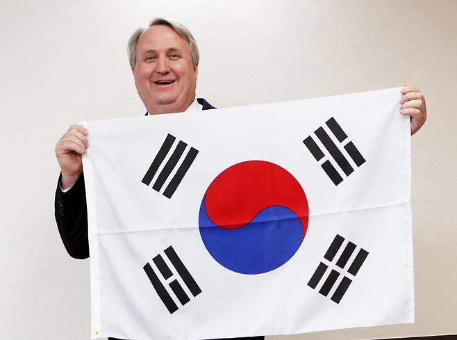 2012년 3월 21일 오후 경기도 과천 법무부청사에서 인요한(53·미국명 존 린턴) 박사가 권재진 법무장관으로부터 대한민국 국적 증서를 받고, 태극기를 들어 보이며 웃고 있다./이태경  기자