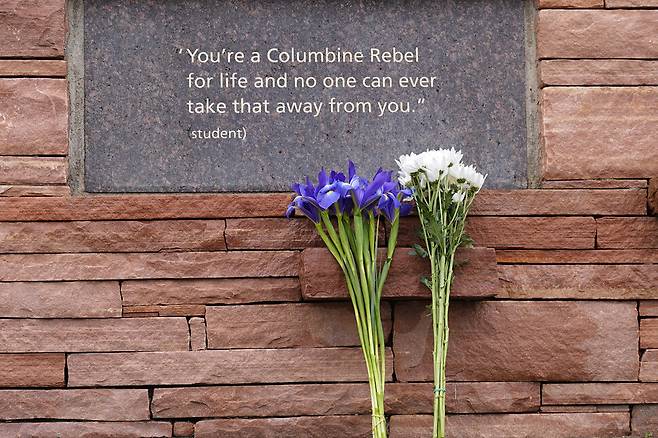 2024년 4월20일(현지시각) 미국 콜로라도주 리틀턴에 있는 ‘콜럼바인 총기 난사 사건’ 추모의 벽에 꽃다발이 세워져 있다. AP 연합뉴스