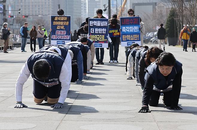 조국혁신당의 김선민 대표 권한대행, 차규근 의원, 서상범 법률위원장과 당 대변인단 등이 13일 서울 광화문 광장에서 윤석열 대통령의 파면을 촉구하는 삼보일배를 하며 헌법재판소로 향하고 있다. [연합]