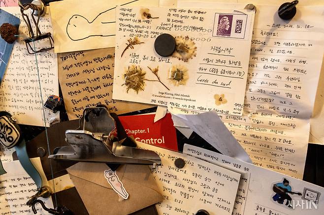 지구불시착 서가에 손님들이 보낸 엽서와 편지가 붙어 있다. ⓒ시사IN 박미소