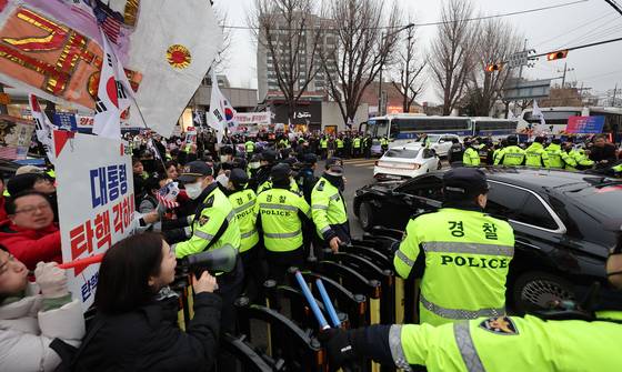 지지자들이 헌법재판관 관용차에 접근하지 못하도록 경찰이 막고 있다. 매일 퇴근시간마다 반복되는 광경이다. 연합뉴스