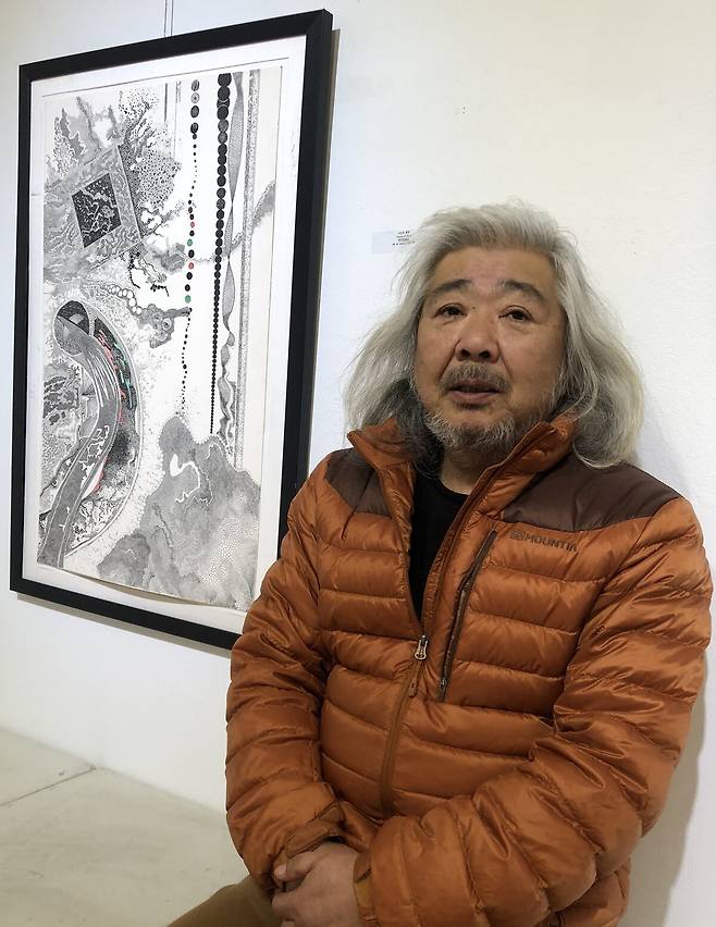 작품 '시간의 흔적' 앞에 앉은 하만홍 작가.