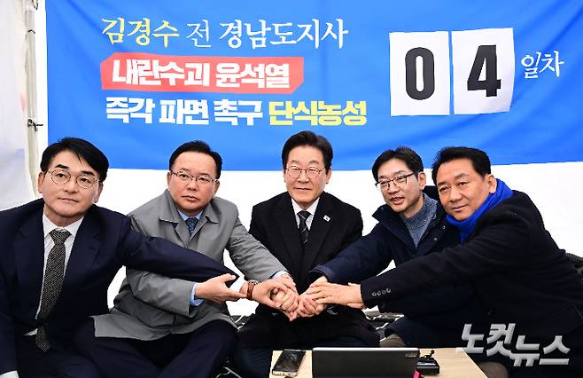 박용진 전 의원, 김부겸 전 국무총리, 이재명 더불어민주당 대표, 김경수 전 경남지사, 이광재 전 국회 사무총장(왼쪽부터)이 12일 오후 서울 광화문 인근 천막에서 윤석열 대통령 파면을 촉구하며 단식 농성에 돌입한 김 전 지사를 응원하며 손을 모아 결의를 다지고 있다. 류영주 기자