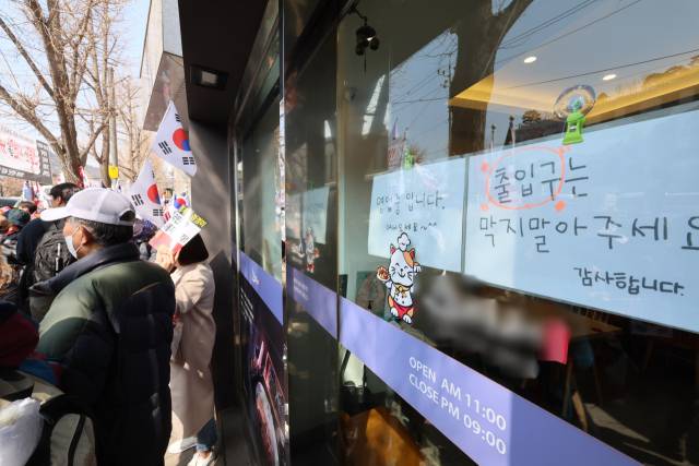 14일 서울 종로구 헌법재판소 인근 한 식당에 정상 영업 안내문이 붙어 있다. 연합뉴스