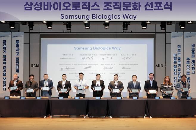 삼성바이오로직스가 6월 20일 노사 공동 조직문화 선포식을 가졌다. 존림 삼성바이오로직스 대표(가운데)와 임원, 직원 대표들이 함께 서약서 작성 후 기념 촬영을 하고 있다. /삼성바이오로직스