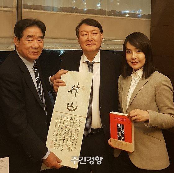 지난 2019년 2월 17일 역술인 서대원 씨(왼쪽)가 윤석열·김건희 부부를 만나 자신이 지어준 호 율산(律山)을 적은 글귀를 들고 기념사진을 찍고 있다. /경향자료 사진, 서대원 제공