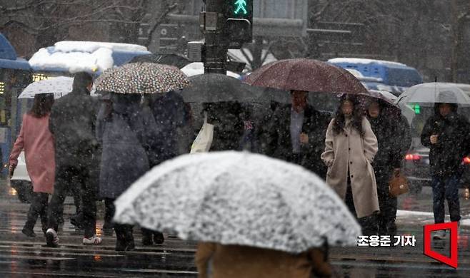 서울 역대 가장 늦은 대설특보가 발효된 18일 서울 종로구 광화문네거리에서 시민들이 눈을 맞으며 출근길을 서두르고 있다. 2025.3.18 조용준 기자