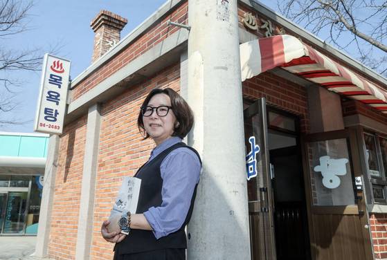 『씻는다는 것의 역사』를 펴낸 이인혜 전 국립민속박물관 학예사가 14일 서울 종로구 국립민속박물관의 야외 ‘장수탕’ 앞에서 포즈를 취했다. 옛날식 목욕탕을 재현한 모형 건물이다. 김성룡 기자