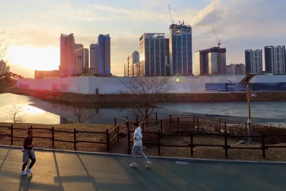 청라호수 한가운데 청라시티타워 부지에 가림벽이 세워져 있다. 그 주변 산책로에서 주민들이 운동을 하고 있다. 김홍준 기자