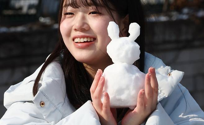 간밤에 많은 눈이 내린 18일 서울 중구 청계천에서 한 일본인 관광객이 직접 만든 눈사람을 들고 기념촬영을 하고 있다. 연합뉴스