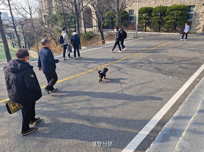 학교 관계자가 운화학원 이사장의 반려견으로 추정되는 강아지를 산책시키고 있다. 독자제공