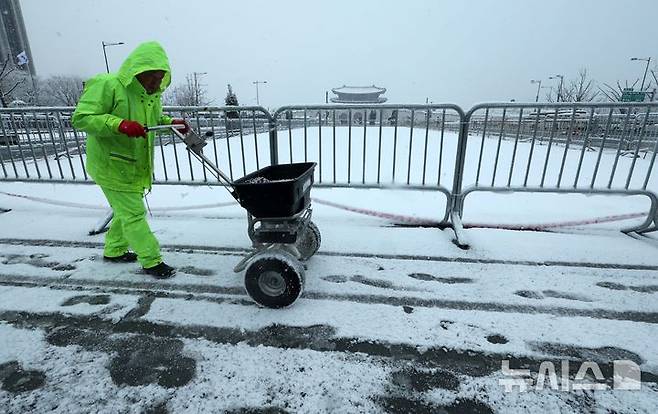 [서울=뉴시스] 고범준 기자 = 서울에 역대 가장 늦은 대설주의보가 내려진 18일 오전 서울 종로구 광화문광장에서 관계자가 제설작업을 하고 있다. 2025.03.18. bjko@newsis.com