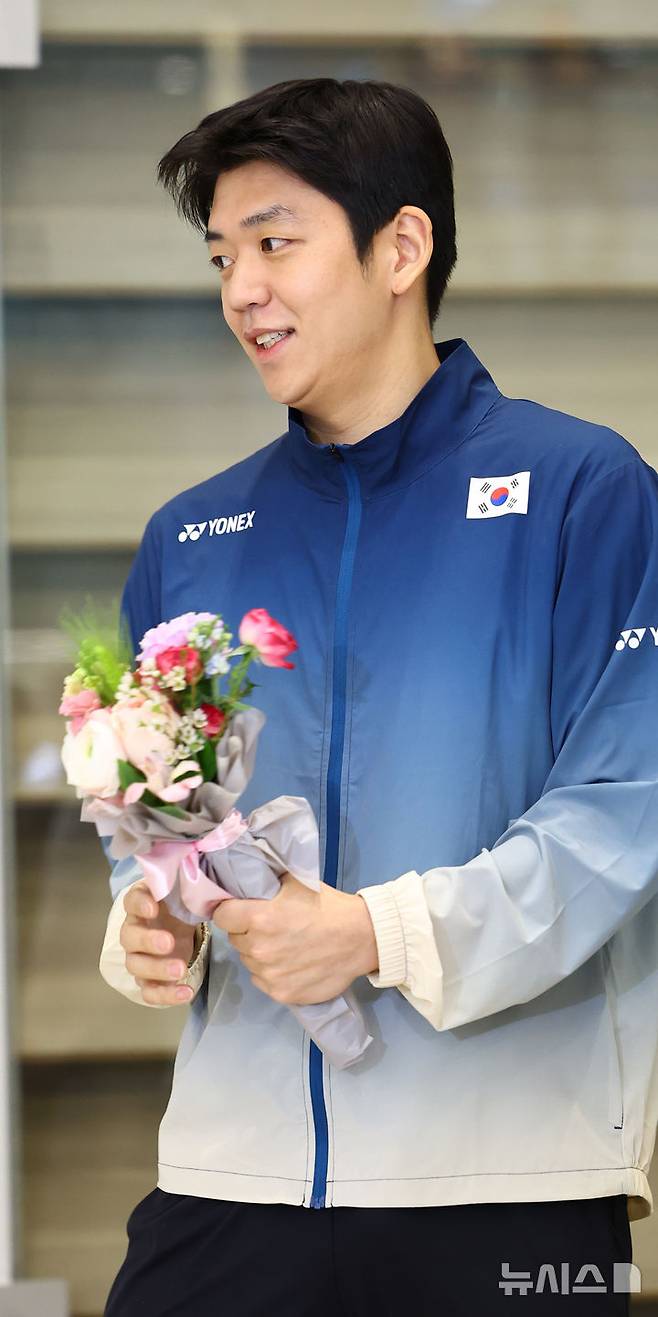 [인천공항=뉴시스] 박주성 기자 = 전영오픈에 초빙 코치로 동행한 이용대가 18일 오후 인천국제공항을 통해 귀국해 대한배드민턴협회 관계자에게 꽃다발을 받고 있다. 2025.03.18. park7691@newsis.com