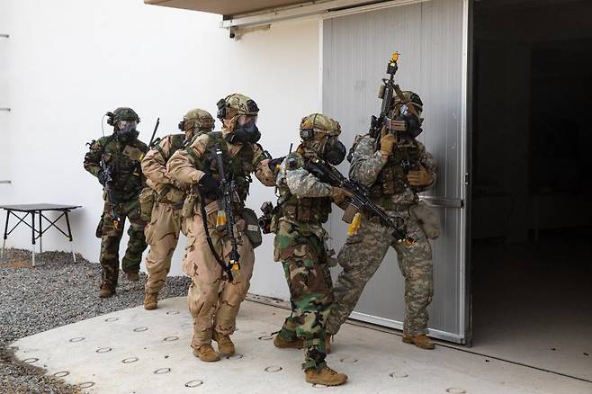 제17보병사단은 2025년 FS/TIGER의 일환으로 지난 16일부터 인천 일대 및 경기도 파주 무건리훈련장에서 '한미연합 전투지휘훈련'을 실시하고 있다고 19일 밝혔다. 17사단은 전군 유일 사단급 한미연합 전투지휘훈련을 실시하는 부대이다. 이번 훈련에는 한미 양국군 장병 1200여 명이 참가하였으며, 전투지휘훈련과 야외기동훈련(CWMD 및 공중기동)을 연계하여 실시해 훈련의 실전성을 높였다. 사진은 CWMD-TF 장병들이 의심시설 출입문을 확보하고 내부로 진입할 준비를 하고 있는 모습. 사진=육군 제공