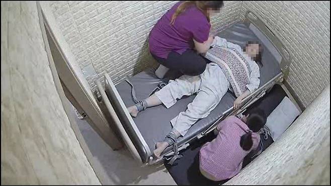 strong지난해 5월27일 부천W진병원에서 피해자 박씨가 복통을 호소하며 문을 두드리자 보호사와 간호조무사가 들어와 약을 먹인 뒤 침대에 묶는 모습. 시시티브이 영상 갈무리/strong