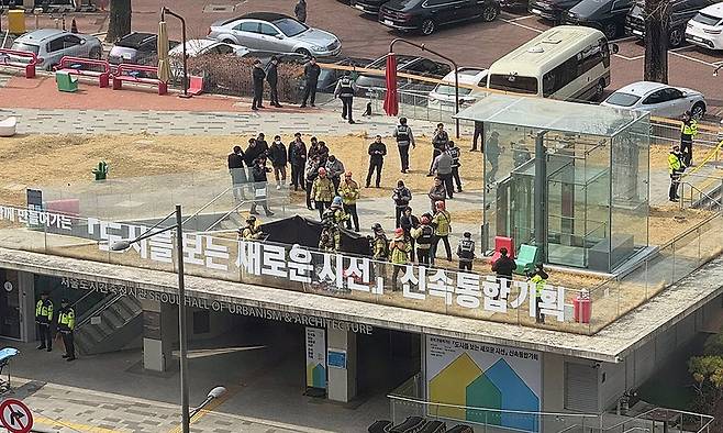 지난 7일 낮 서울 중구 도시건축전시관 옥상에서 소방관들이 윤석열 대통령 지지자로 추정되는 한 남성의 분신 시도 현장을 수습하고 있다. 연합뉴스